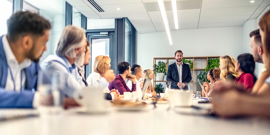 full sales team looking to their manager for answers in a modern conference room