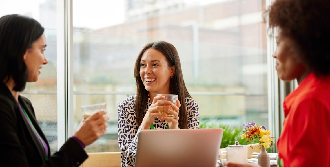 sales enablement leaders at a conference table celebrating their crowdsourced sales enablement content