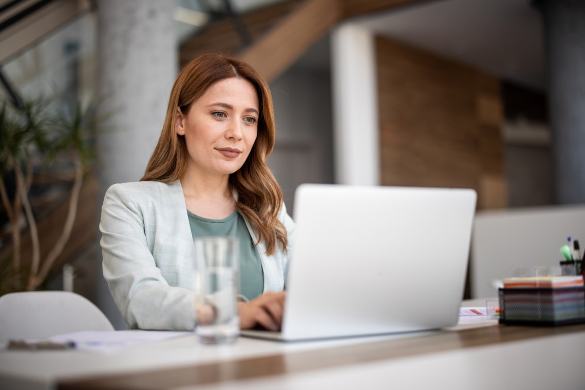 professional woman sitting a computer doing research into sales training