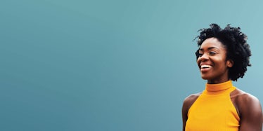 young professional woman in a yellow shirt against a teal background