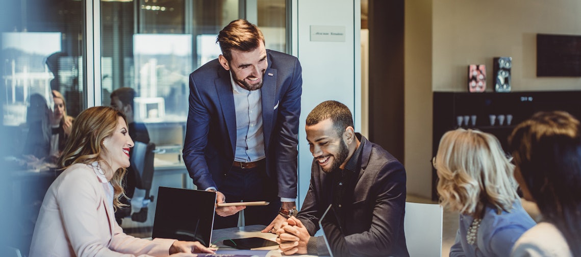 a team of account managers around a conference room table working together to apply the strategies discussed in the prosperous account strategy program to find new revenue opportunities in their top accounts.