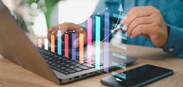 Man on laptop with chart graphic overlay showing positive growth.