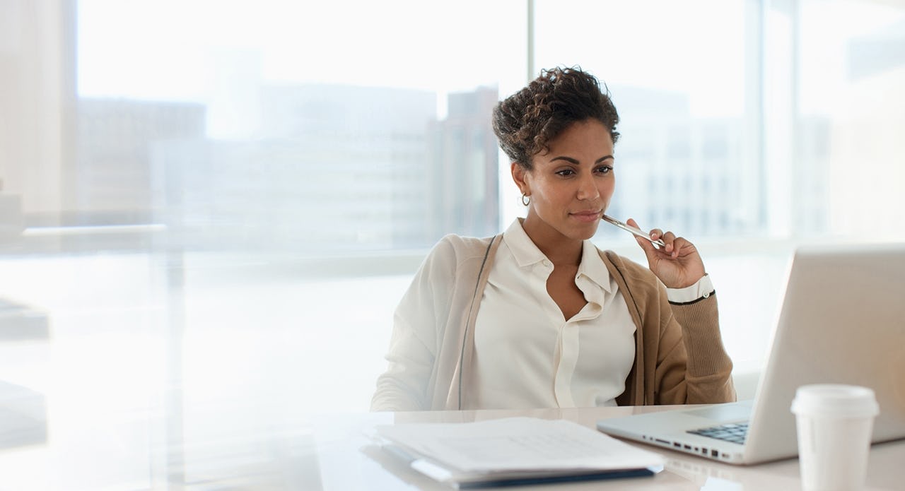 female salesperson sitting at her office desk working hard to get to her next level of success because her manager has used the approach taught in the driving salesperson accountability training module to increase her sense of accountability.