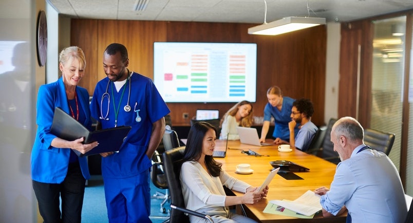 goup of medical professionals and sales professionals working on a deal