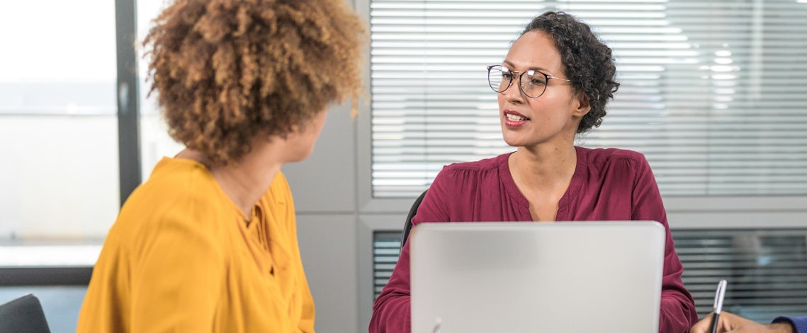 close up of a sales woman and her customer having an engaging conversation at a conference table
