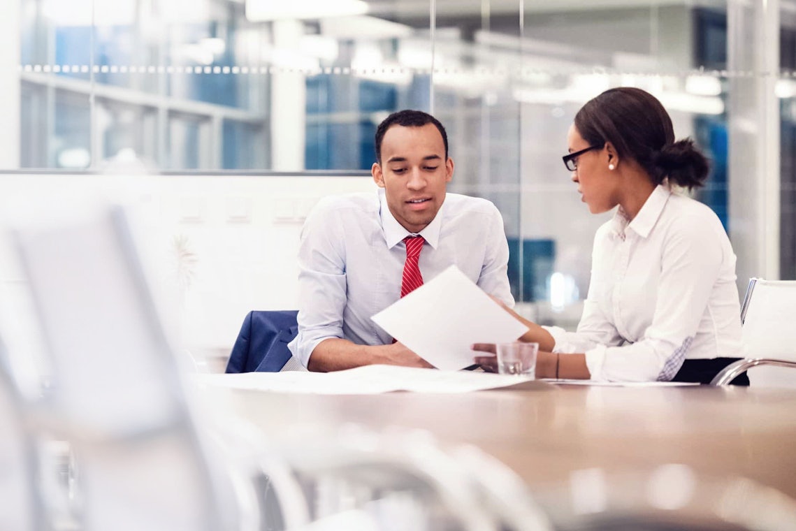 young man and woman in a modern office collaborating on an account plan that creates opportunities for new business because of the customer-centric nature of the seller's account management strategy.