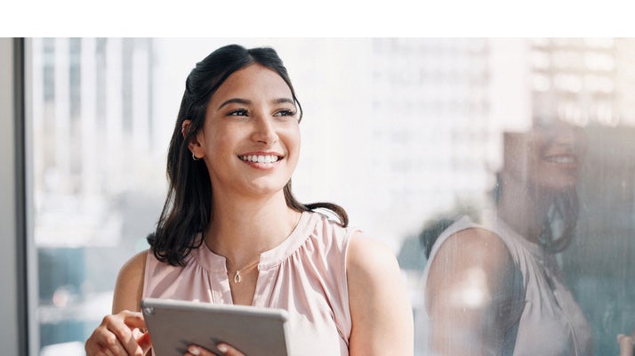 young account manager on an ipad smiling because her account management tools are helping her identify, create, and make the most of opportunities with existing clients